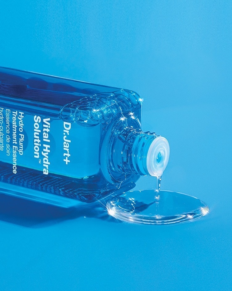 A bottle of Vital Hydra Solution Essence gently pours liquid essence.